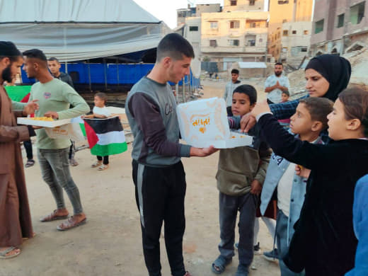 Gazans in Khan Yunis distribute sweets to celebrate the killing of Israeli-backed militant Yasser Abu Shabab in Rafah