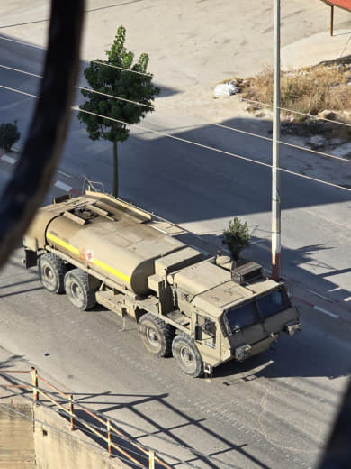 The occupation forces push a military truck carrying diesel fuel to their forces in Jenin.