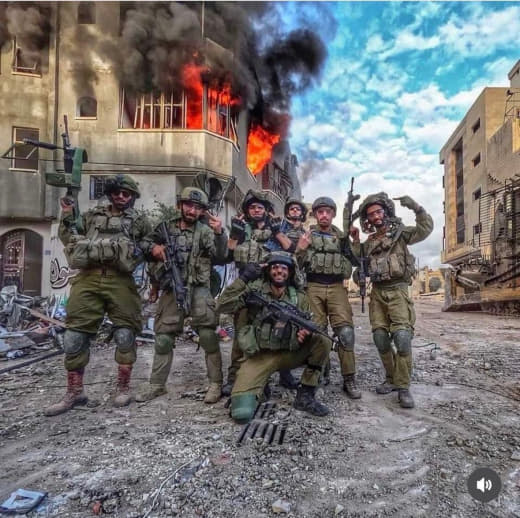 Israeli soldiers from Battalion 7007 in Gaza make an inappropriate hand gesture after burning a house, signifying their 