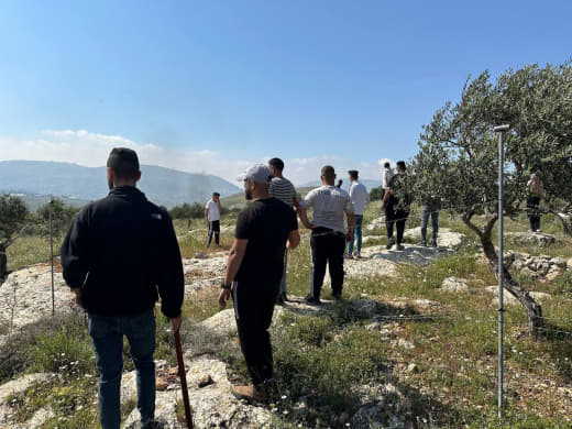 Palestinians from the town of Beit Furik in the occupied West Bank stand ready in groups on the outskirts of the town to
