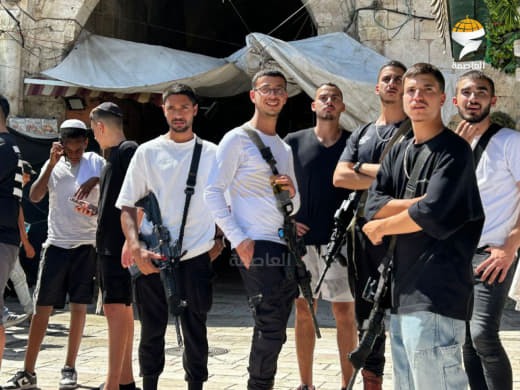 Armed Israeli settlers pose for a picture at one of the entrances to the Old City of Jerusalem ahead of the provocative 
