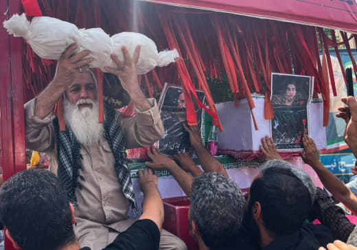 An elderly man holds the body of an infant killed in a recent Israeli airstrike on the city of Isfahan, Iran.
